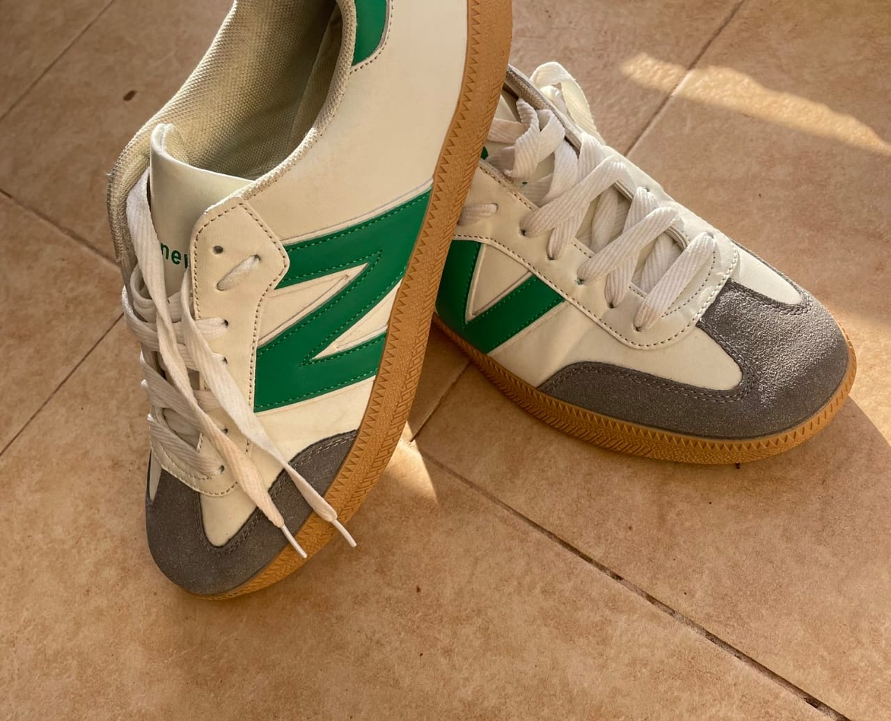 A white and green smooth newbalance sneaker