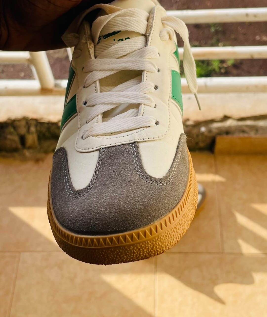 A white and green smooth newbalance sneaker